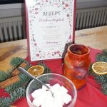 Das Bild zeigt eine Schale mit Würfelzucker, Weihnachtsdekoration und ein hübsch gestaltetes Rezept für "Weihnachtsglück".